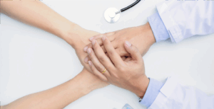 Patient and doctor holding hands