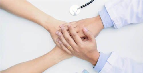 Patient and doctor holding hands
